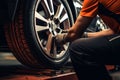 Professional mechanic changing car tyres in auto repair service center. Technician man working at auto repair service center. Royalty Free Stock Photo