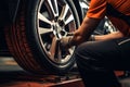 Professional mechanic changing car tyres in auto repair service center. Technician man working at auto repair service center.