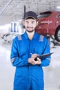 Professional mechanic holding clipboard