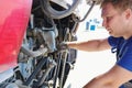 Professional mechanic inspects and repairs bus engine. Royalty Free Stock Photo