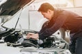 professional mechanic male work tune engine ignition timing in ecu with laptop computer in auto service garage racing shop