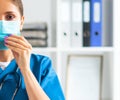 Professional medical doctor working in hospital office, Portrait of young and attractive female physician in protective Royalty Free Stock Photo