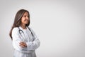 Professional medical worker. Portrait of happy senior woman doctor in white coat standing with folded arms, free space Royalty Free Stock Photo