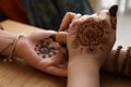 Professional mehndi master making henna tattoo at table, closeup Royalty Free Stock Photo