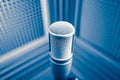 Professional microphone in sound recording studio, blue acoustic foam background