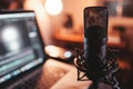 Professional microphone with warm ambient lighting against blurred laptop background, podcast. Royalty Free Stock Photo