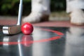 Professional minigolf player starts to hit the ball.