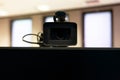 Professional modern video camera above a blank monitor screen closeup, frontal shot. Streaming video, vlogging career Royalty Free Stock Photo