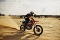 Professional motocross rider driving on sand dune