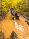 A professional motorcyclist stuck in the muddy swamp of a forest, faces the challenge of navigating through the wild