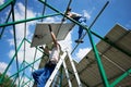 Professional mounters team installing solar batteries on metallic carcass. Royalty Free Stock Photo