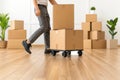 Professional movers carefully loading, packing, and unloading cardboard boxes in new apartment amidst stacked paper cont Royalty Free Stock Photo