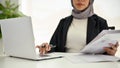 Professional Muslim businesswoman using laptop, analyzing data, working in her office Royalty Free Stock Photo