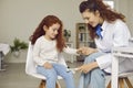 Pediatric neurologist examining happy little child and using hammer to test knee reflex Royalty Free Stock Photo