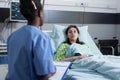 Professional nurse reading patient chart on clipboard providing medical health care to patient with low spo2 Royalty Free Stock Photo