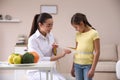 Professional nutritionist measuring waist of little girl
