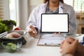 Professional nutritionist in white coat showing digital tablet and giving consultation to patient in clinic Royalty Free Stock Photo