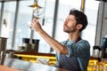 Professional Occupation. Bartender standing at counter checking clarity of wine glass concerned Royalty Free Stock Photo