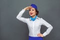 Professional Occupation. Stewardess standing isolated on grey looking forward laughing playful