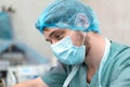 A professional ophthalmologist performs eye surgery with a microscope. The anesthesiologist controls the anesthesia and the