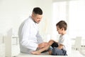 Professional orthopedist examining patient`s leg in clinic