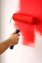 Professional Paint Roller Applying Bold Red Color For Dynamic Interior Wall Renovation Royalty Free Stock Photo