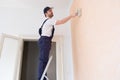 Professional painter worker is painting one wall Royalty Free Stock Photo