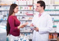 Professional pharmaceutist in drugstore helping girl Royalty Free Stock Photo