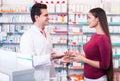 Professional pharmaceutist in drugstore helping girl Royalty Free Stock Photo