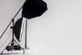 Professional photo studio with light setup included octagon softbox on boom, strip soft box and reflector on light gray background