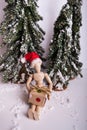 Jointed wooden mannequin doll wearing Santa Claus hat sitting holding a holiday present
