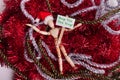 Shop Til You Drop sign held by wooden jointed manikin doll laying on tangled mess of garland wearing Santa hat Royalty Free Stock Photo