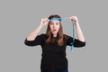 Lady measuring head with blue measuring tape surprised look on her face