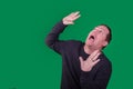 Man being attacked or surprised by something above him on green screen background