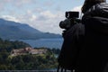 Professional photographer in a black jacket taking stunning landscape photos of a mountain range