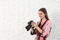 Professional photographer with  camera near white brick wall. Space for text Royalty Free Stock Photo