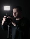 Professional photographer with camera on tripod.isolated on black background Royalty Free Stock Photo