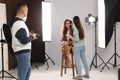 Professional photographer and makeup artist with model in studio Royalty Free Stock Photo