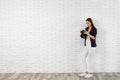 Professional photographer with modern camera near white brick wall Royalty Free Stock Photo