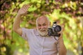 Professional photographer. Pension hobby. Senior man photographer blooming trees background. Cameraman retirement