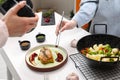 Professional photographer taking photo while food stylist decorating composition with meat medallion in studio, closeup Royalty Free Stock Photo