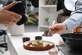 Professional photographer taking photo while food stylist decorating composition with meat medallion in studio, closeup Royalty Free Stock Photo