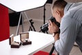 Professional photographer taking picture of expensive wristwatches in studio