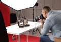 Professional photographer taking picture of expensive wristwatches in studio