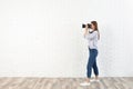 Professional photographer taking picture near white brick wall Royalty Free Stock Photo
