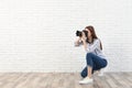 Professional photographer taking picture near white  wall. Space for text Royalty Free Stock Photo