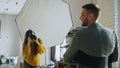 Professional photographer woman taking photo of businessman model girl with digital camera in studio