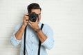 Professional photographer working near white brick wall in studio. Space for text Royalty Free Stock Photo