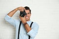 Professional photographer working near white wall in studio. Space for text Royalty Free Stock Photo