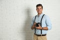 Professional photographer working near white wall in studio. Space for text Royalty Free Stock Photo